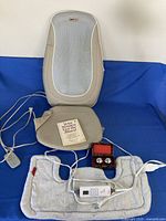 All items laid out: Obusforme massager back and seat sections, heating pad with controller, Baoding balls in box, book