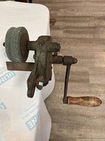 Side view showing grinder body, stone wheel, and crank handle