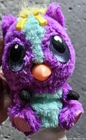 Front view of purple Hatchimal plush showing eyes, beak and teal belly