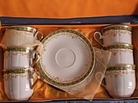 Overview of boxed set showing six cups and top saucer