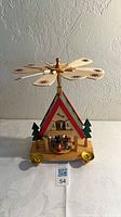 Full view of wooden nativity pyramid showing fan blades, roof, base, and candle holders