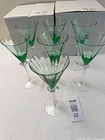 Seven green goblets in front of original boxes
