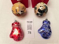 Two hand-painted round ornaments and two mitten ornaments displayed with lot tag