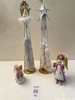 Group shot of four angel figurines showing relative sizes and bases