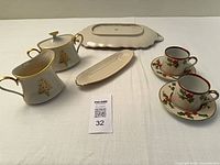 Full lot overview showing platter, butter dish, creamer, sugar bowl, two cups with saucers