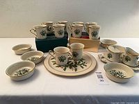 Full set arranged showing mugs, bowls, platter, tray, sugar and creamer