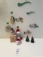 Full lot overview showing mobile on wall, nutcracker on box, plush snowmen, wood trees, gold angel, Santa head