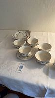 Six handled soup bowls with six saucers on table