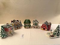 Front view of five ceramic buildings and snowman accessory