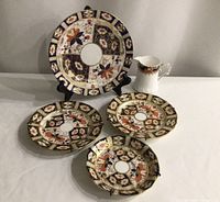 Overall lot view showing four plates and creamer