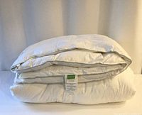 Folded king feather and down duvet with label visible