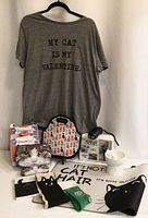 All items grouped: T-shirt on hanger, ThunderShirt box, lunch bag, carrier package, socks, makeup bag, diffuser, bowl, rolled mat