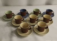 Front angled view of all nine cup and saucer sets