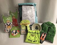 Group shot of all dog items including playpen, bandanas, grooming tools, bowl, jacket, T-shirt