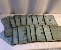 Fourteen softcover volumes laid out to show quantity and general condition