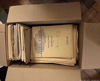 Open box showing stacked sheet music with Practical Method for Violoncello on top