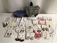 Full layout of approximately 25 jewellery cards with two makeup bags behind