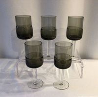 Front view of all five smokey stemmed glasses on riser