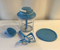 Complete set arranged: bowl with pull-cord lid, chopping blade inside, whisk insert, funnel, flat cover