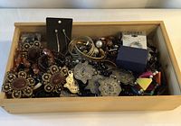 Overview of wooden tray filled with assorted jewellery