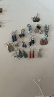 Overview of all 15 earring pairs arranged on surface
