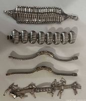 Front view of all five silver-tone bracelets aligned