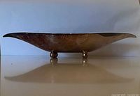 Side profile showing silver-tone exterior and ball feet