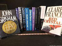 Front view of row of hardcover books on supports showing spines and two front covers