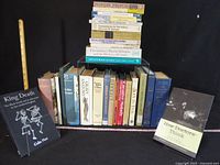 All books upright, one leaning left, another laid front right