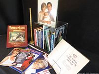 Overall lot view showing books in acrylic holder, separate hardcover and magazines