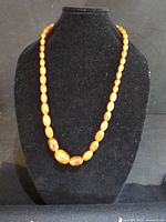 Orange bead necklace on display bust