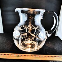 Overall view of cut crystal pitcher showing handle, spout and cut pattern with ruler for scale