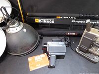 Overall lot showing boompole, studio light reflector, camera, projector and film cartridge