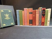 Full lot showing all 12 spines with additional decorative green board