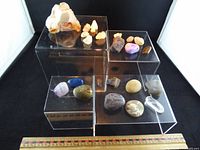 Overall view of all mineral specimens on acrylic risers with ruler for scale