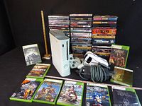 Overall lot showing Xbox 360 console, controller, VR headset, power supply, nine Xbox 360 games, large stack of PS2 games