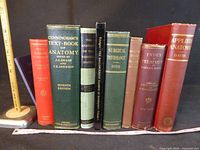 Spines of eight vintage medical books with ruler for scale
