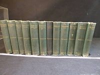 Spine view of all 12 volumes showing uniform green cloth and gilt titles