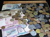 Overview of mixed world coins and several banknotes on surface