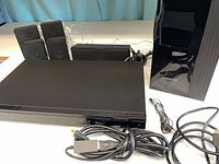 Full view of DVD unit, four satellite speakers, center speaker, subwoofer, cables