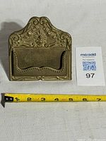 Front view showing ornate floral design and size reference tape