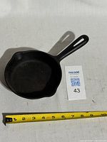 Top view of cast iron frying pan with measuring tape showing diameter