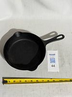 Top view of Javelin P-105 cast iron frying pan beside measuring tape showing roughly 8 in. diameter