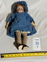 Full view of doll with tape measure showing length