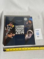 Front cover of sealed 2014 Collection Canada stamp yearbook with measuring tape for scale
