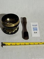 Singing bowl on cushion with striker and tape measure showing diameter