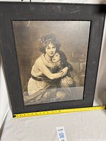 Full view of framed lithograph with measuring tape showing size