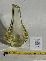 Full view of citrine art glass vase beside scale