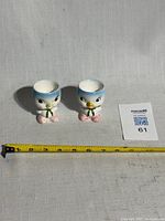 Front view of both bluebird egg cups with tape measure for scale