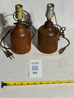 Front view of both teak lamps with measurement tape